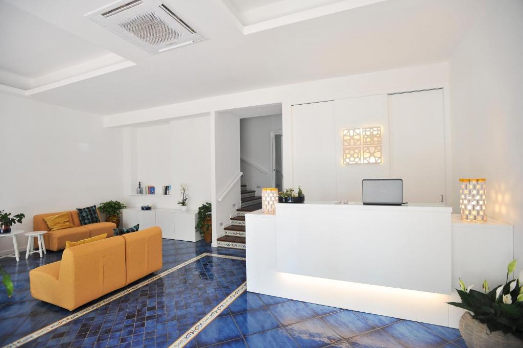 an office with a reception counter and orange chairs at Residence Panoramic in Maiori