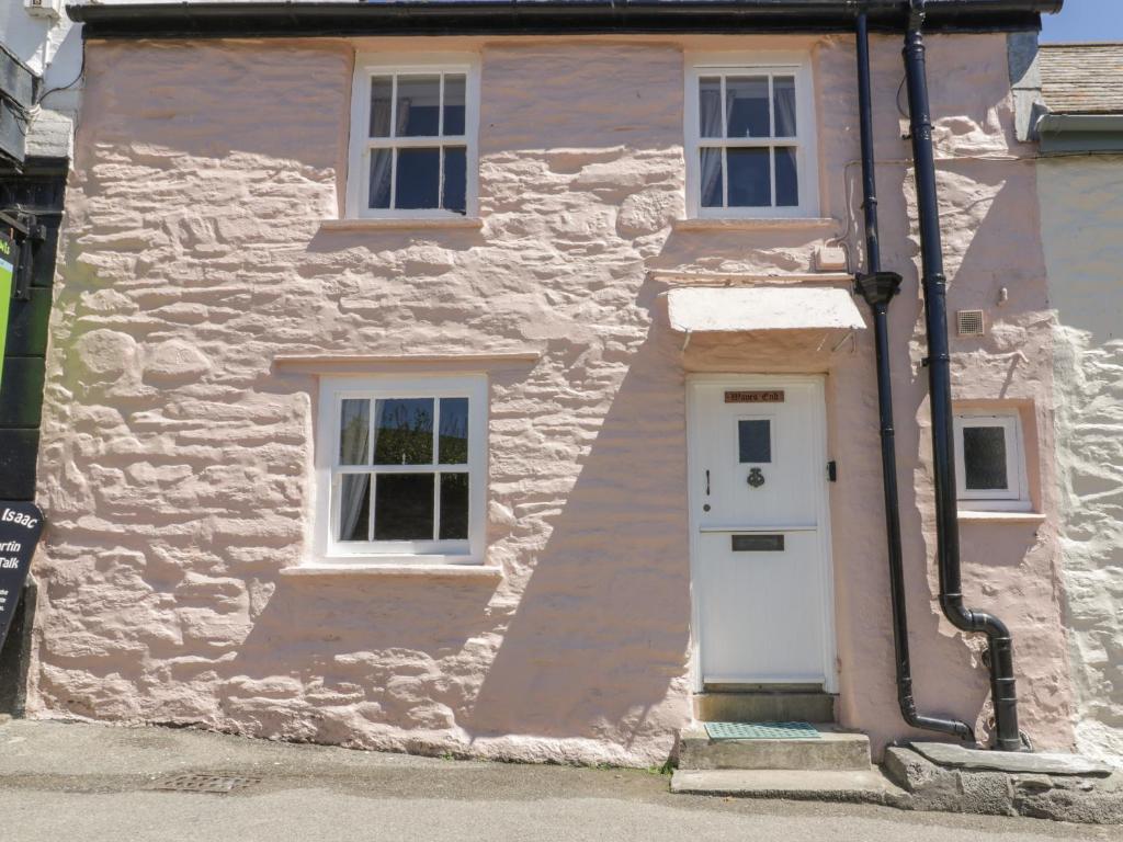 a white house with a white door and windows at Waves End in Port Isaac