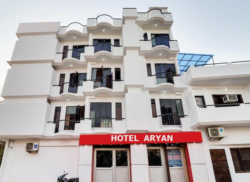 a hotel with a red sign in front of it at Hotel Aryan in Lucknow