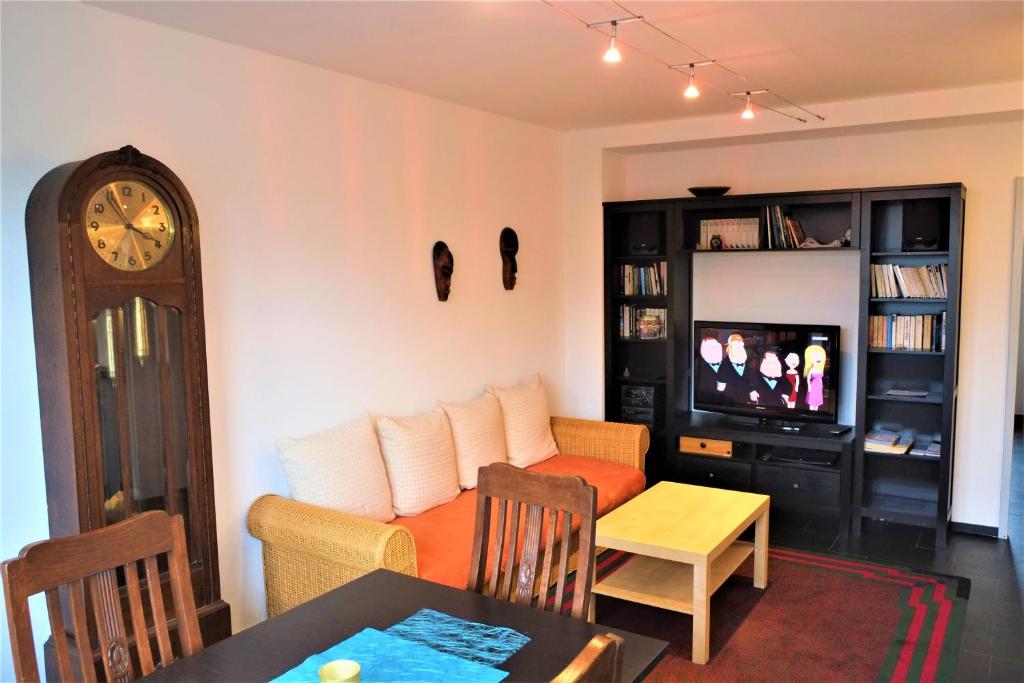 a living room with a couch and a clock at City Apartments Cologne - Apartment 1 in Cologne