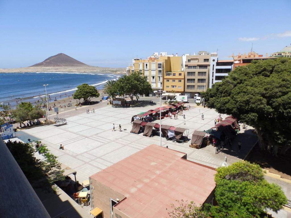 a city square with a beach and buildings and the ocean at Apartamentos Medano - Playa Grande in El Médano