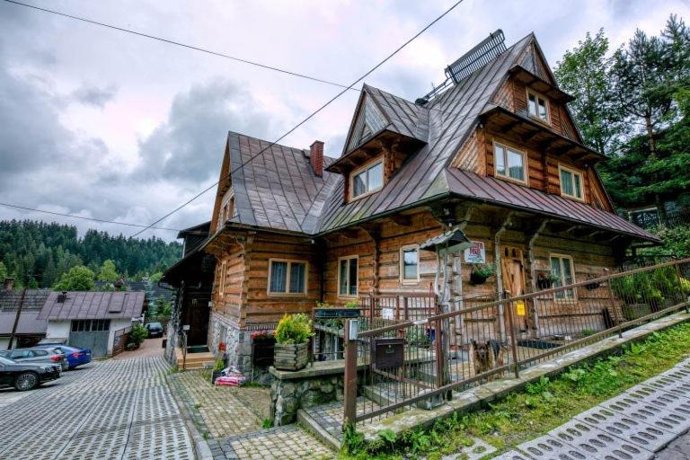 uma grande casa de madeira com um telhado de gambrel em Pokoje Gościnne Dawidek em Zakopane