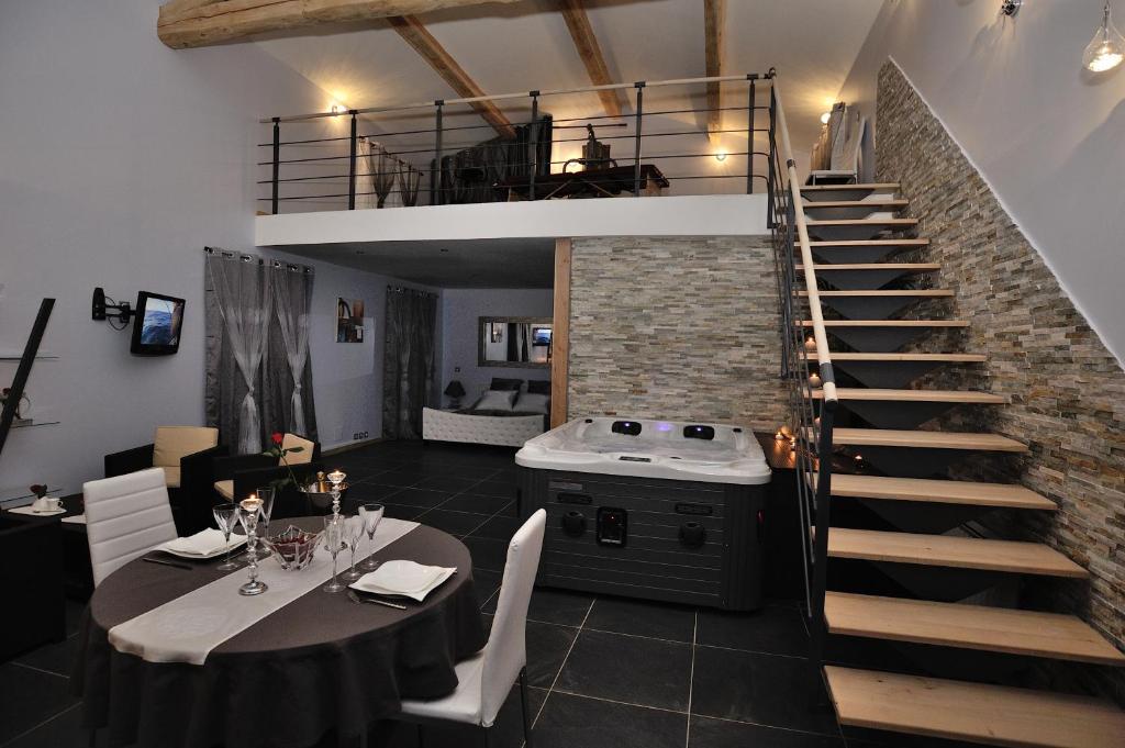 La villa des délices في Saint-Privat-des-Vieux: غرفة طعام مع طاولة ودرج حلزوني
