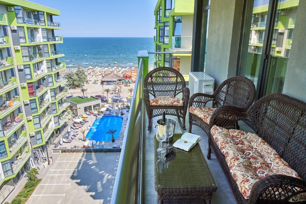 balcón con sillas y vistas a la playa en Berlin luxury apartment Spa n Pool Beach resort, en Mamaia Nord – Năvodari