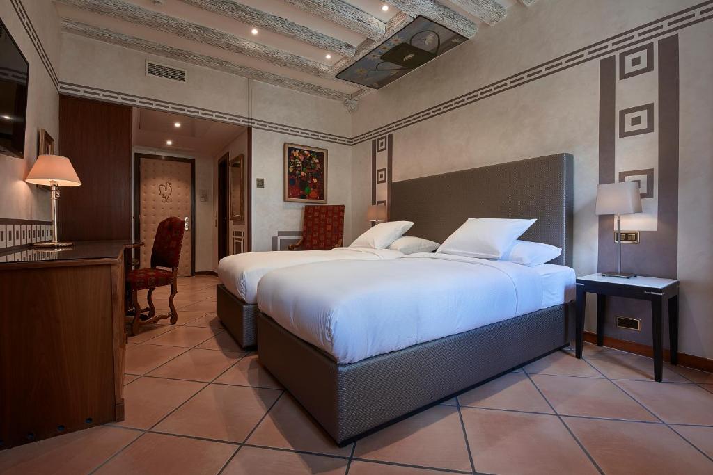 a large bedroom with a large bed and a desk at Hotel d'Allèves in Geneva