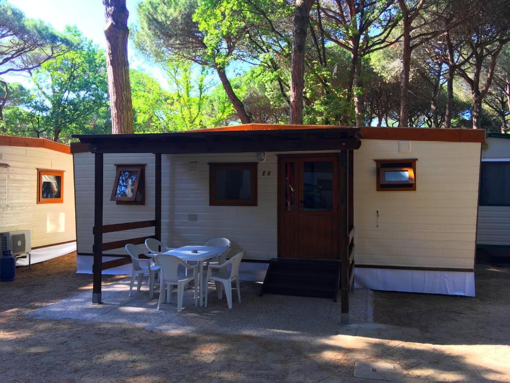 una pequeña casa con una mesa y sillas frente a ella en Buona Mobile Homes, en Lido di Spina