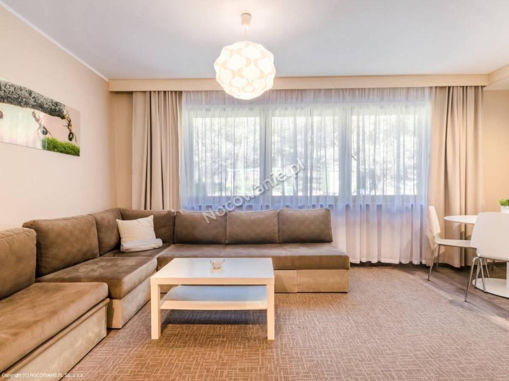 a living room with a couch and a table at Villa Leśna in Mosty