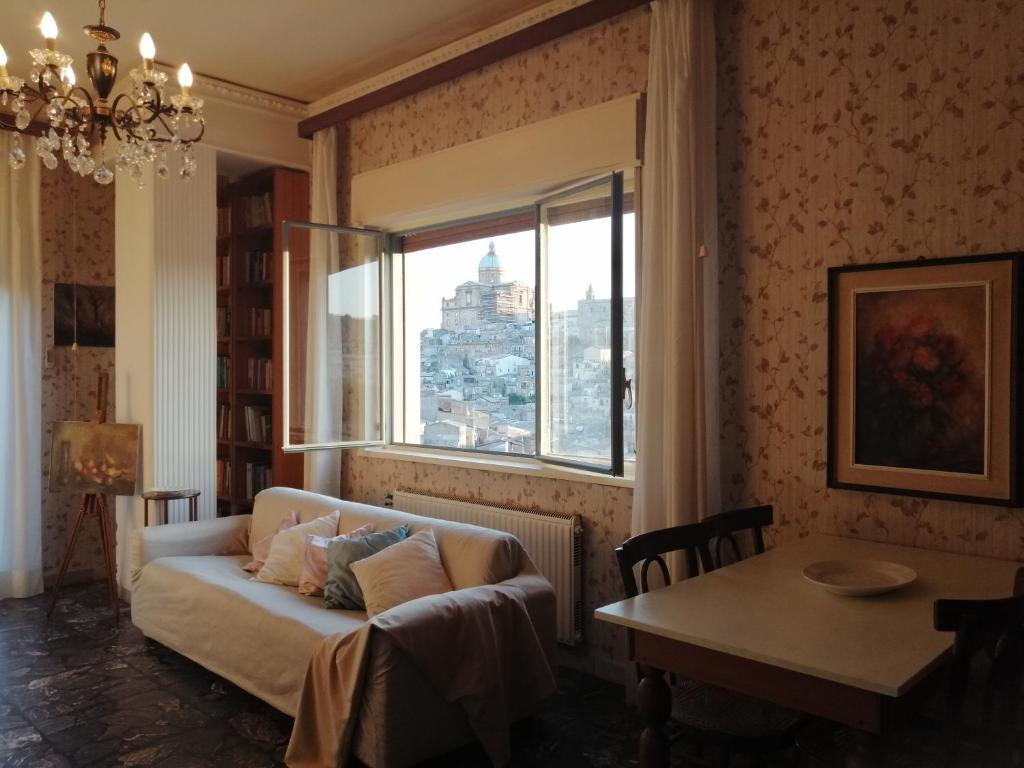 uma sala de estar com um sofá e uma janela em Appartamento d'Artista em Piazza Armerina