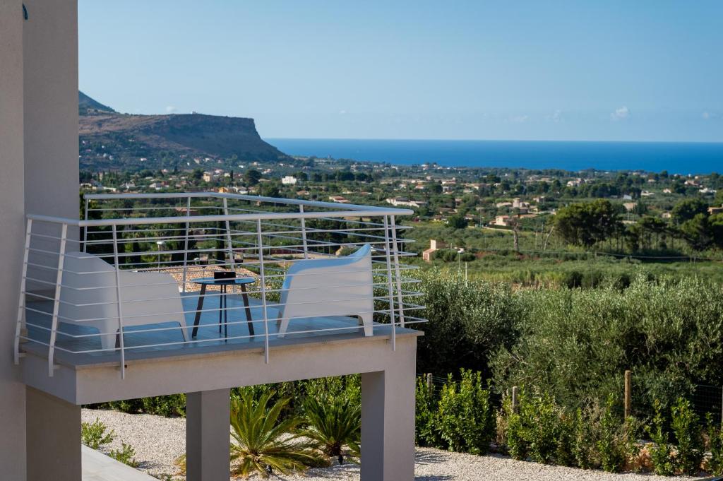 Una silla en un balcón con vista al mar. en Giardino degli Allori - Villa Flores, en Castellammare del Golfo
