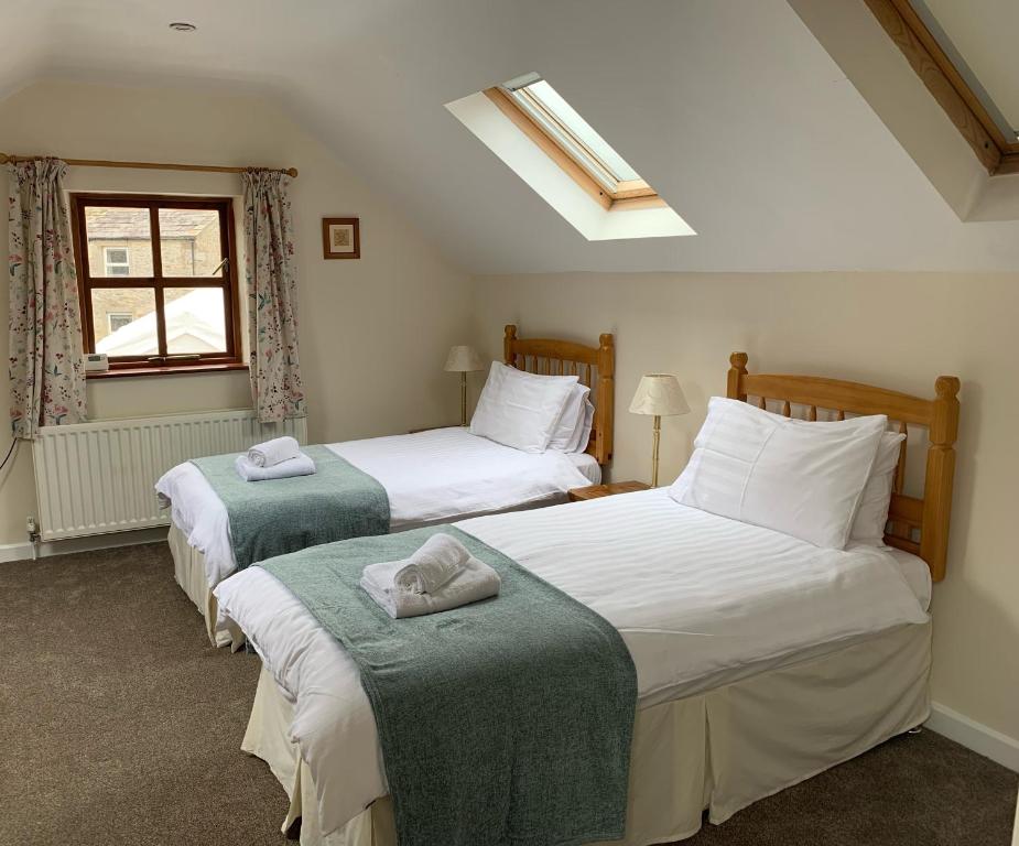 a bedroom with two beds and a window at Fox and Hounds Cottage, Starbotton in Starbotton