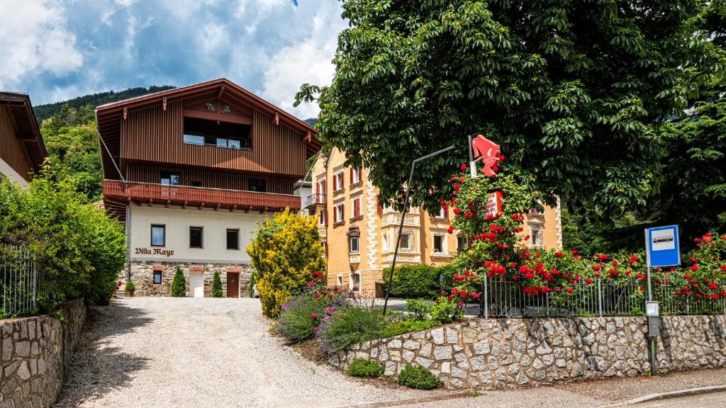 BrixenにあるHotel Villa Mayr Rooms & Suitesの柵と花の前の建物