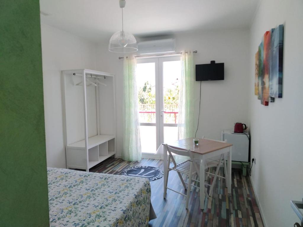 een slaapkamer met een bed, een tafel en een raam bij PiGreco in Albenga
