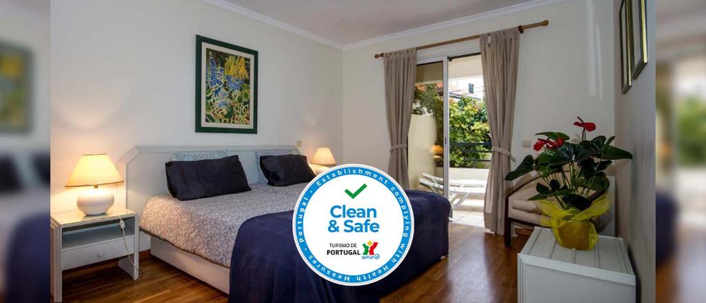 a bedroom with a bed with a sign that says clean and safe at Apartamento Infante in Funchal