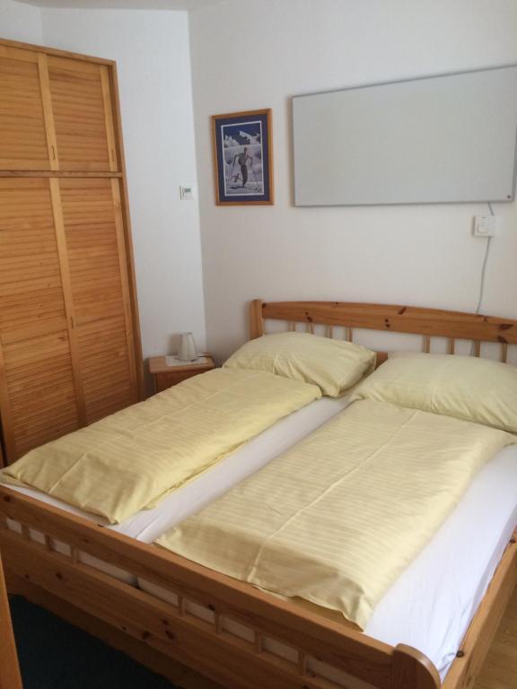 two beds in a bedroom with a board on the wall at Eisenhut Suite 3 in Turracher Hohe