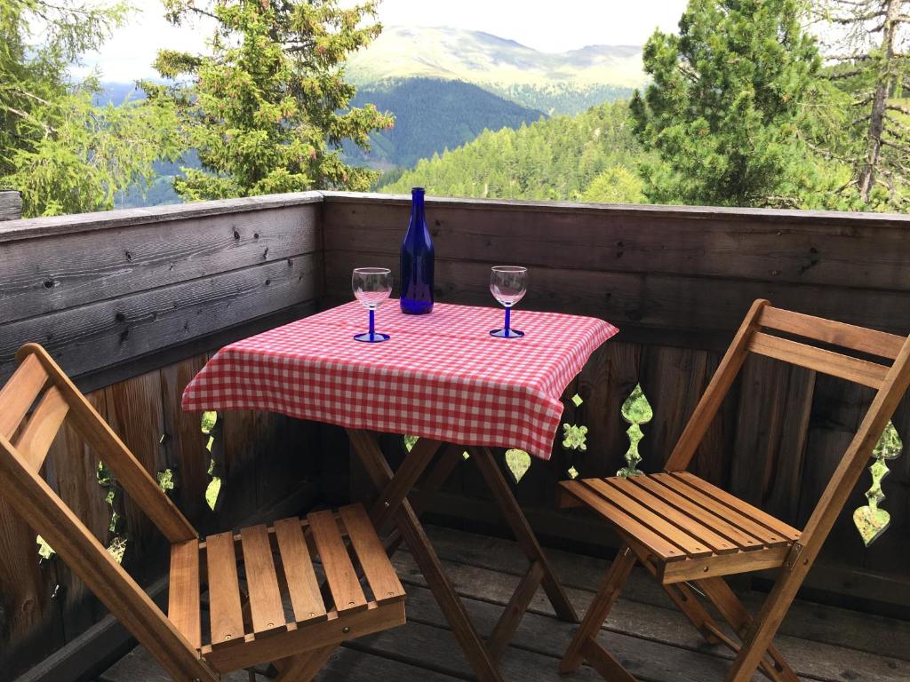 a table with two glasses of wine and two chairs at Eisenhut Suite 3 in Turracher Hohe