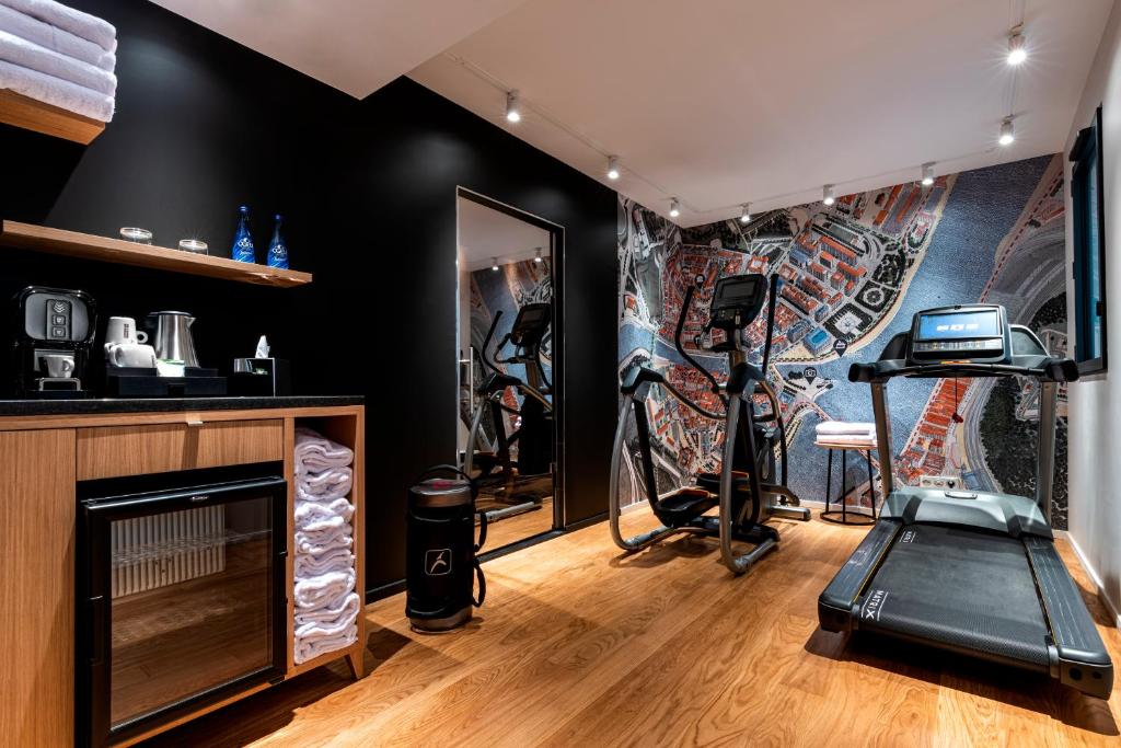 a room with a gym with a treadmill and a fireplace at Hôtel Villa KOEGUI Bayonne in Bayonne
