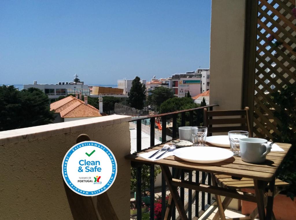 una mesa en un balcón con un cartel que diga limpio y seguro en As Mimosas en Sesimbra