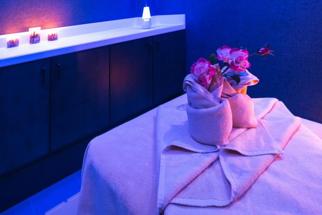 a purple room with a bed with a sink and flowers at Ayla Bawadi Hotel & Mall in Al Ain