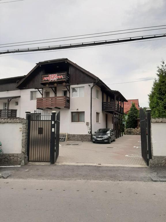 a building with a car parked in a parking lot at Casa Anemyra in Braşov