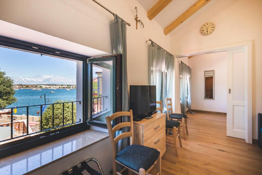 a room with a large window with a view of the water at VINEA APARTMANI UMAG, Ulica G Garibaldia 2 in Umag