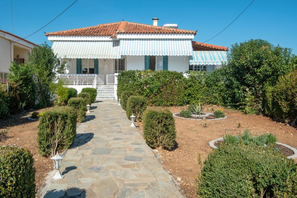 a house with a walkway in front of a yard at Villa Magnolia in Nafplio