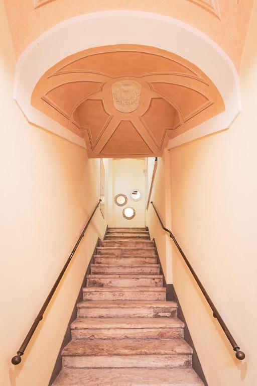 a staircase in a building with a wooden ceiling at Drogheria e Locanda Franci in Montalcino