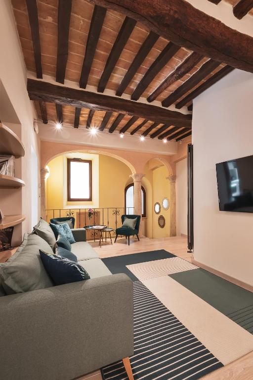 a living room with a couch and a tv at Drogheria e Locanda Franci in Montalcino