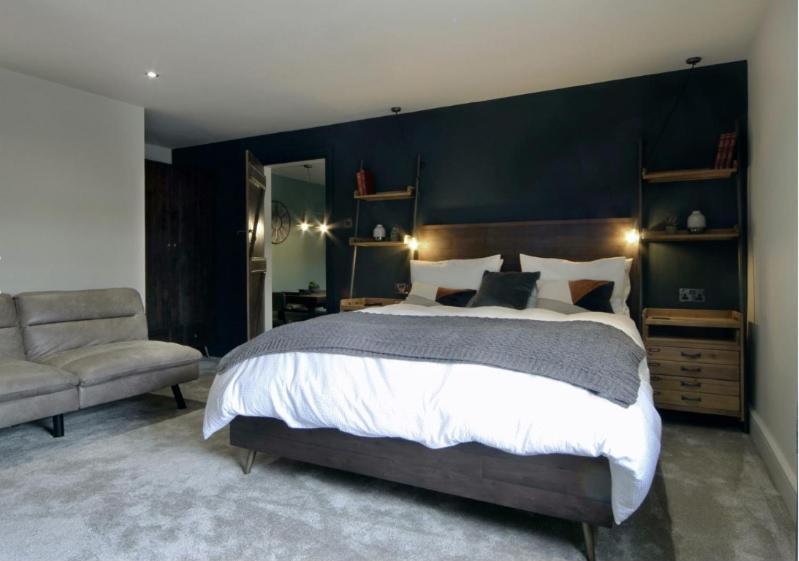 a bedroom with a large bed and a chair at Mount Pleasant Cottages in Richmond