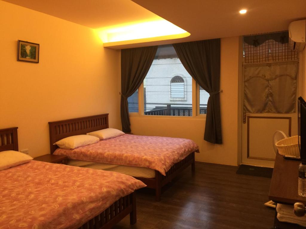 a hotel room with two beds and a window at Golden flower Homestay in Yuli