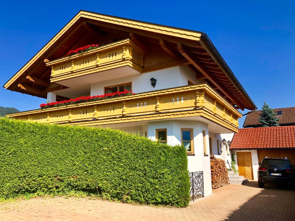 een geel en wit huis met een dak bij Ferienwohnung mit Bergblick in Unterammergau