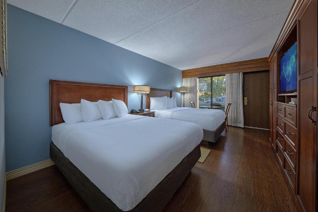 a hotel room with two beds and a large window at The Inn On The River in Pigeon Forge