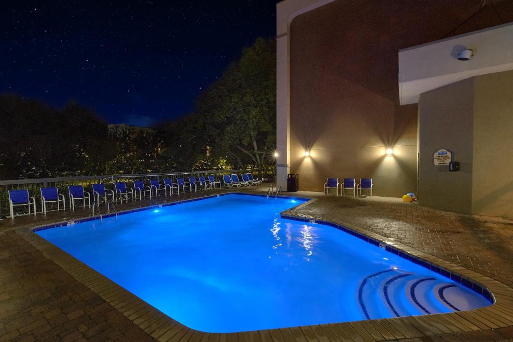 a swimming pool at night with chairs around it at The Inn On The River in Pigeon Forge