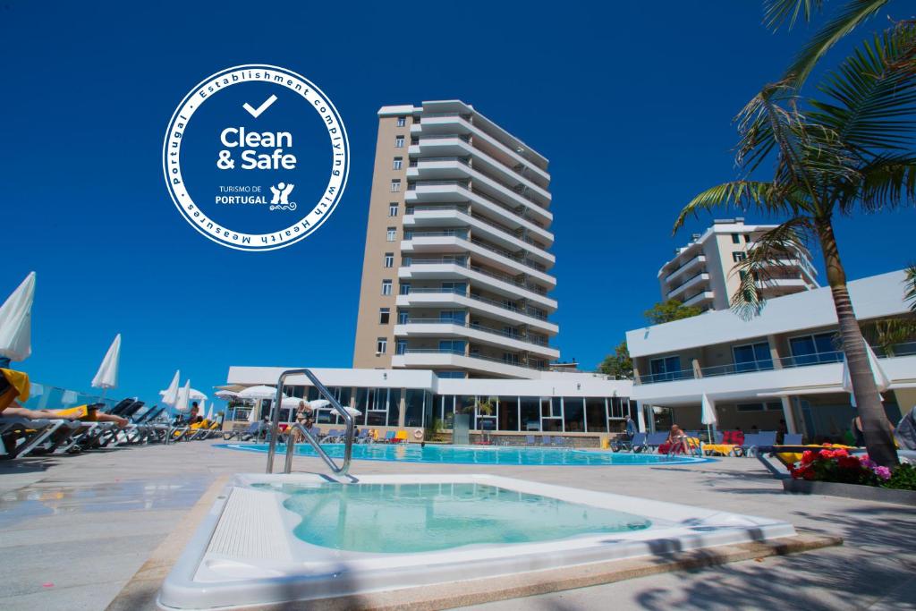 un hôtel avec une piscine en face d'un bâtiment dans l'établissement Duas Torres Hotel, à Funchal