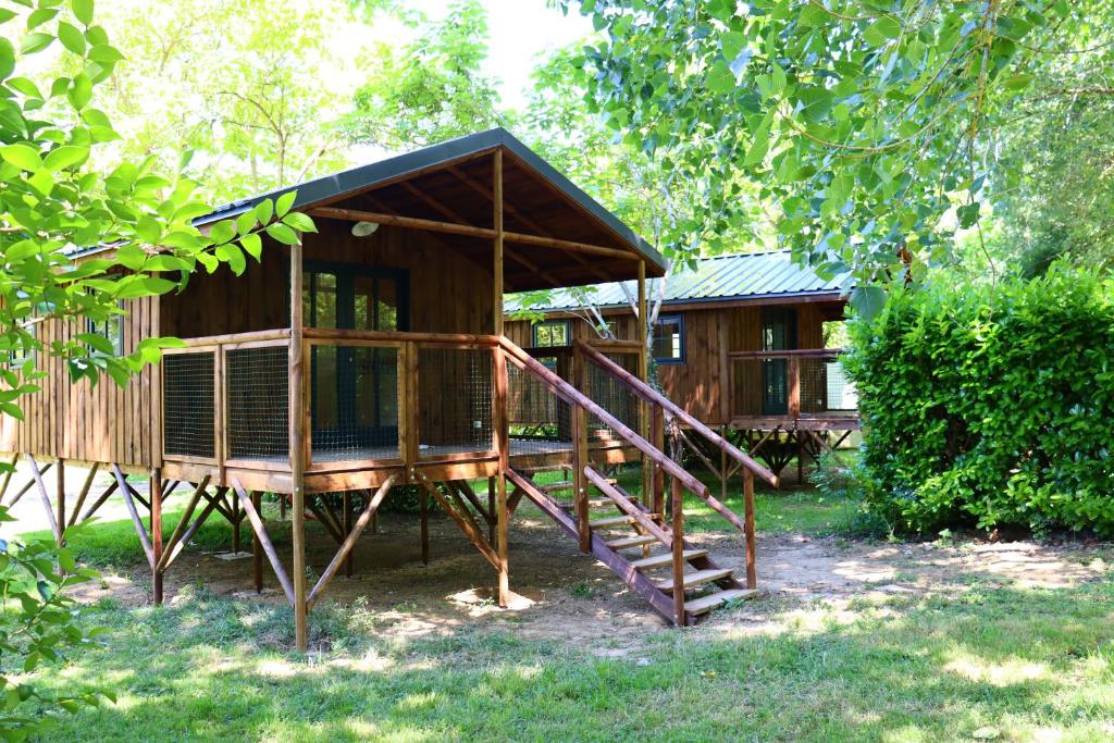 a wooden cabin with a staircase leading to it at Camping Le Mouliat in Moncrabeau