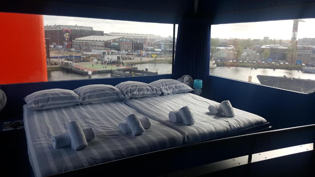 a large bed in a room with a large window at Botel in Amsterdam