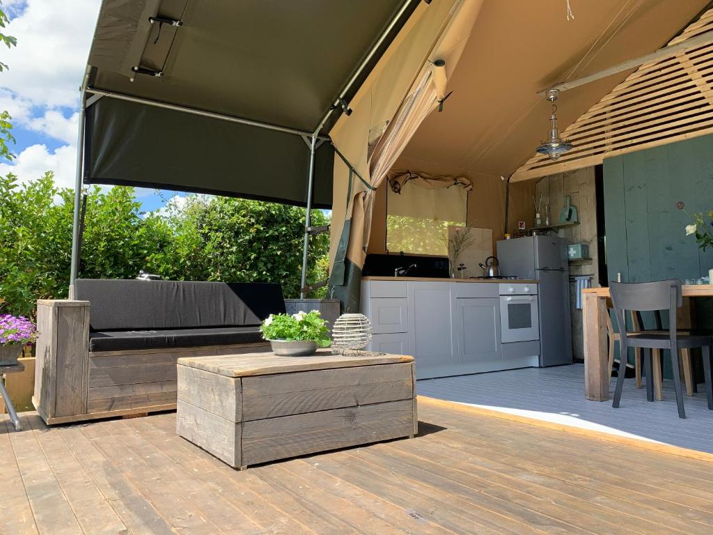 a large tent with a kitchen and a table at Glamping aan de Plas in Vinkeveen