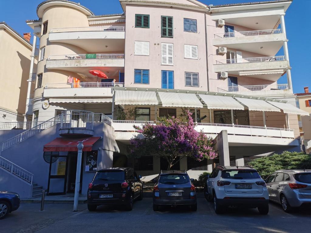 un parking avec des voitures garées devant un bâtiment dans l'établissement Portofino app, à Izola
