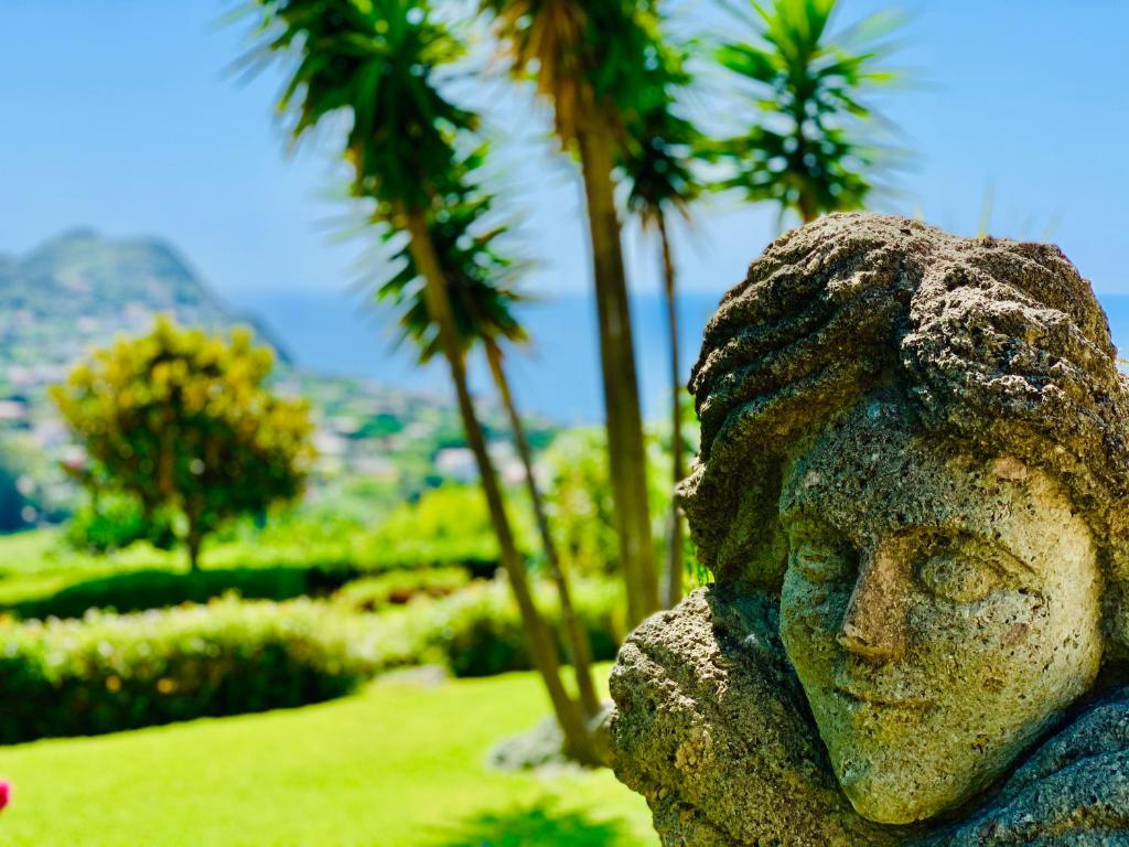 una statua di una donna con palme sullo sfondo di Casa Ischitana a Ischia