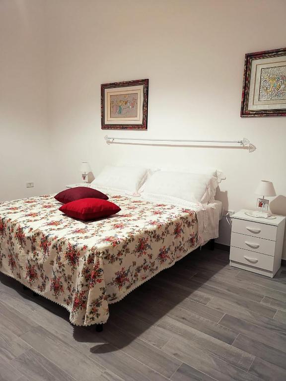 a bedroom with a bed with a red pillow on it at A Casa di Santé in Arnesano