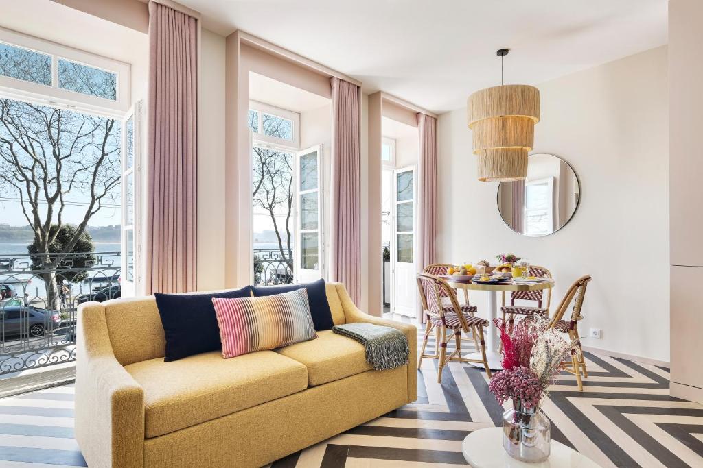 a living room with a yellow couch and a table at Vila na Praia Foz Luxury Apartments in Porto