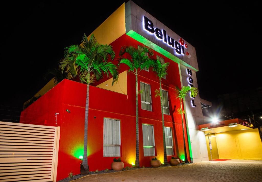 um edifício vermelho com um sinal de néon em Hotel Belugi em Goiânia