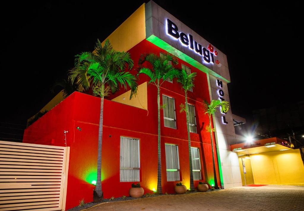 a red building with a neon sign on it at Hotel Belugi in Goiânia