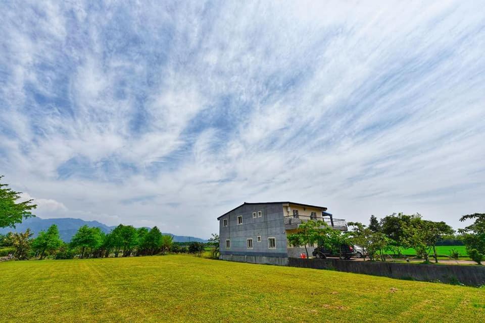 a house on a grassy field with a cloudy sky at Full power in Pa-wang-wei