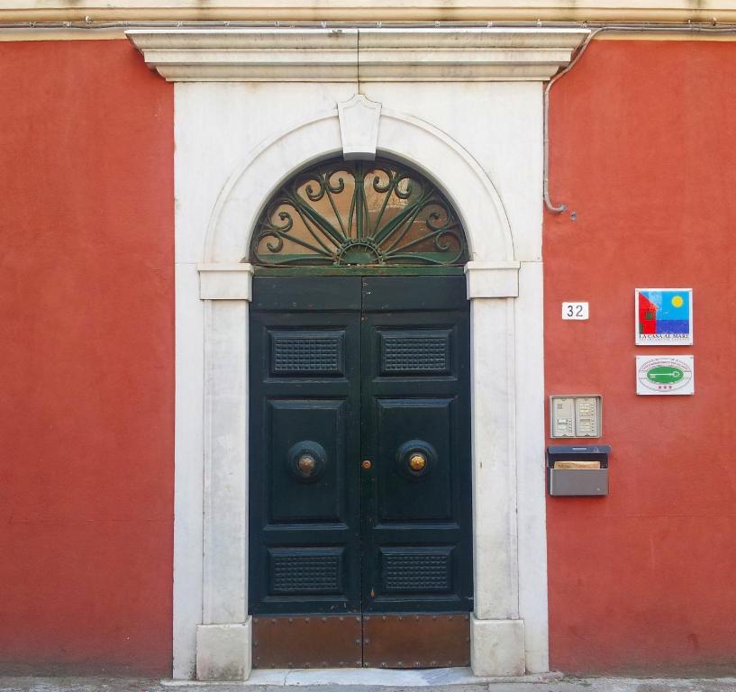 una puerta negra en un edificio rojo y blanco en La Casa al Mare, en Lerici