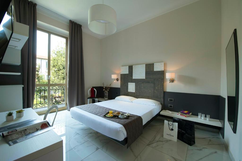 a hotel room with a large bed and a balcony at Hotel San Francisco in Milan