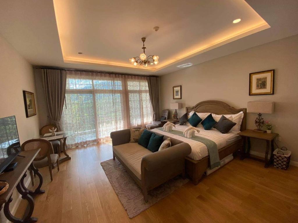 um quarto grande com uma cama e um sofá em The Castell Condo by Nutthiwan room 912 and 921 em Khao Kho