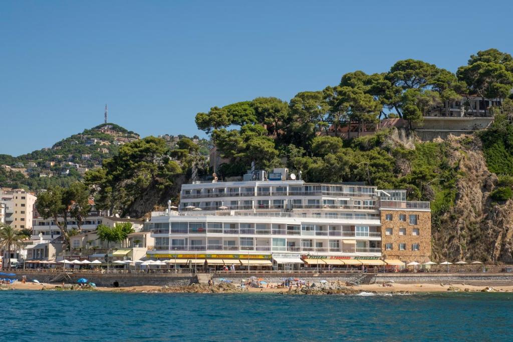 a large building on the beach next to the water at Hotel Rosamar Maxim 4*- Adults Only in Lloret de Mar