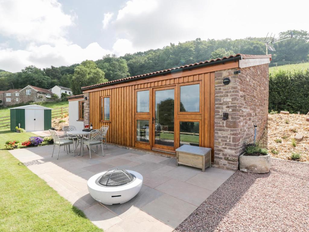 a tiny house with a toilet on a patio at The Comfy Cow in Usk