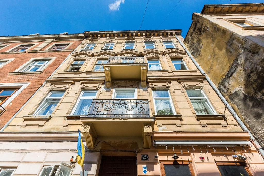 un edificio alto con balcone sul lato di Квартира подобово на Площі Ринок 39 сам центр Львова a Lviv