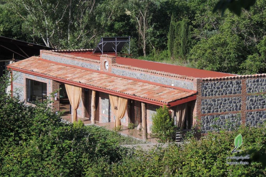 une maison en briques avec un toit rouge sur une colline dans l'établissement Hotel Lopota Gate, à Napareuli